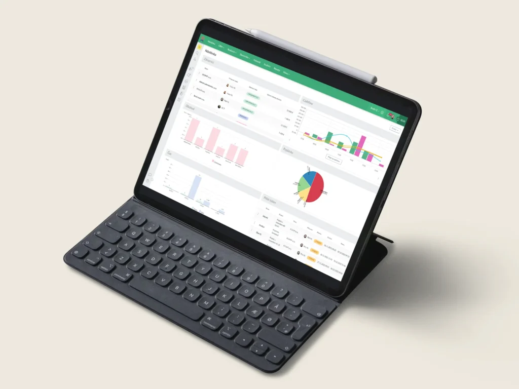 Tablet s klávesnicí zobrazuje přehledný dashboard systému Caflou s grafy, tabulkami a analýzou firemního cashflow a projektů.